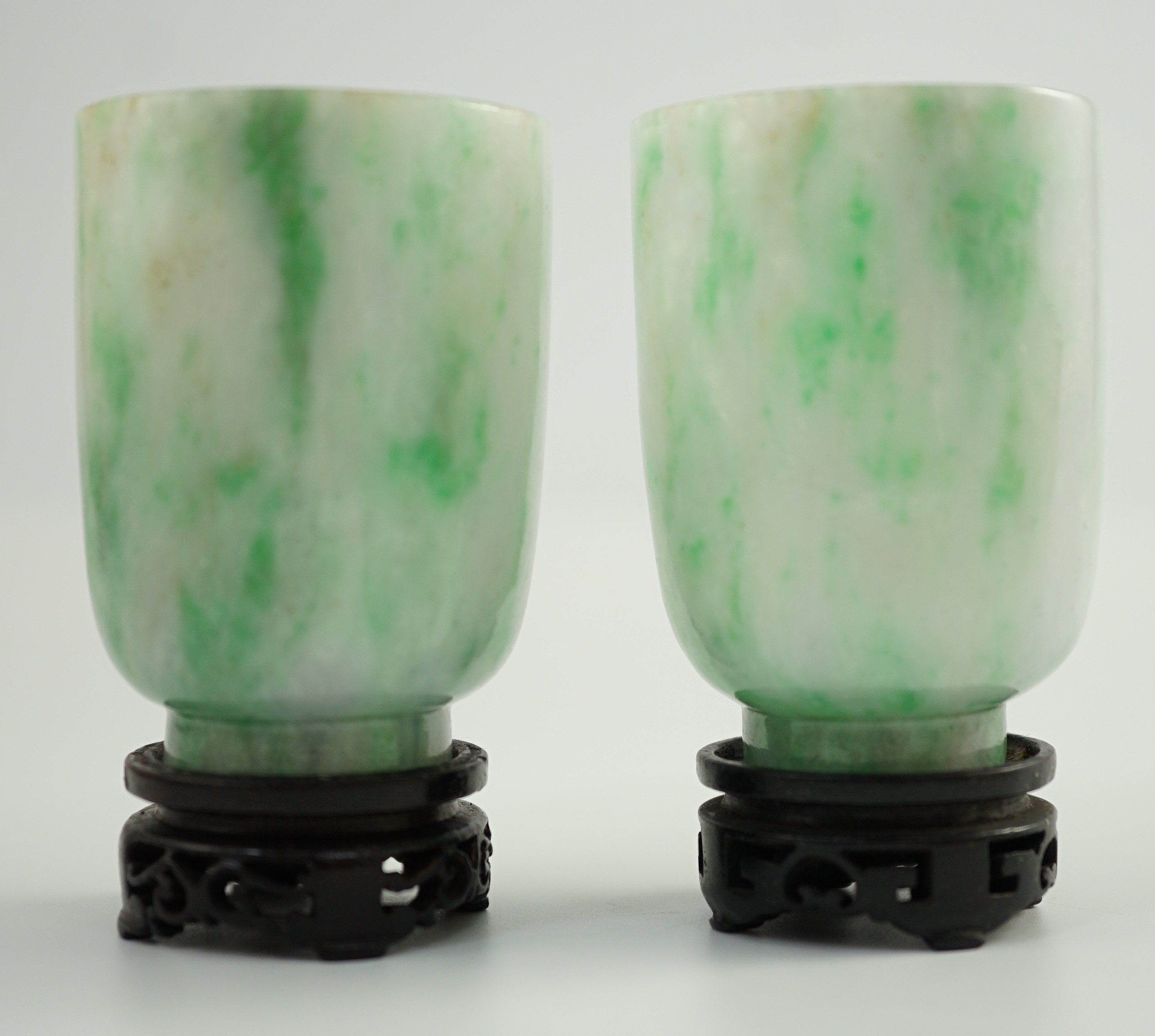 A pair of Chinese jadeite cups, 6.2cm high, wood stands, fitted box